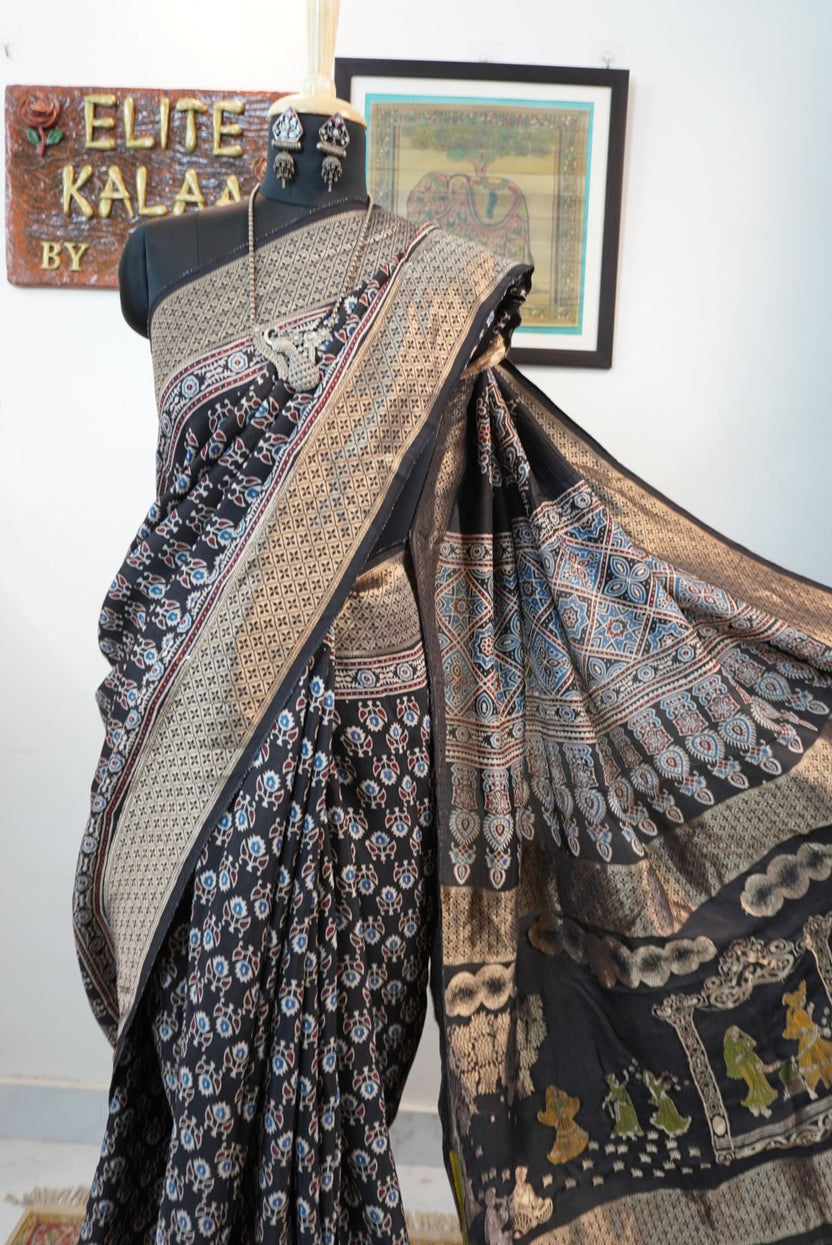 Black Dola silk Ajrakh saree with all-over pattern, border, tassels and multicolor accents