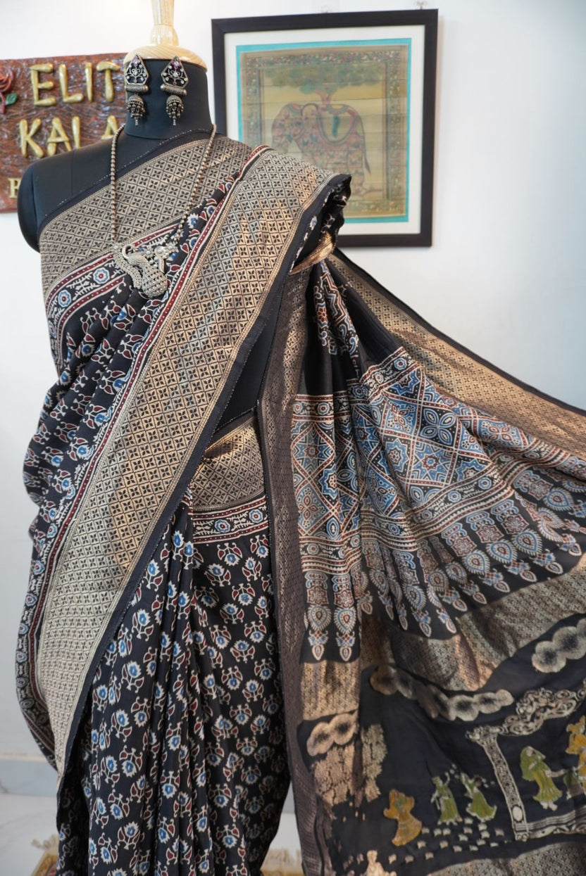 Black Dola silk Ajrakh saree with all-over pattern, border, tassels and multicolor accents