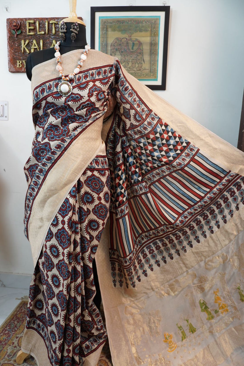 Cream Dola silk saree with Ajrakh block print, multicolor detailing and border