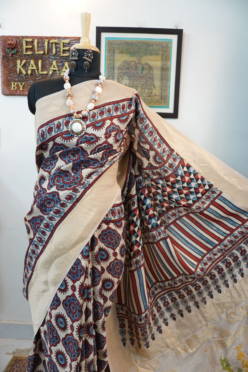 Cream Dola silk saree with Ajrakh block print, multicolor detailing and border