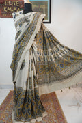Ivory cotton Ajrakh saree with olive green, blue and yellow block print, border and tassels