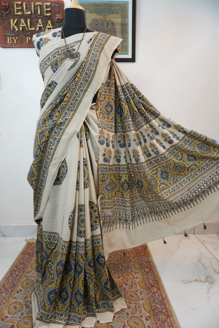 Ivory cotton Ajrakh saree with olive green, blue and yellow block print, border and tassels