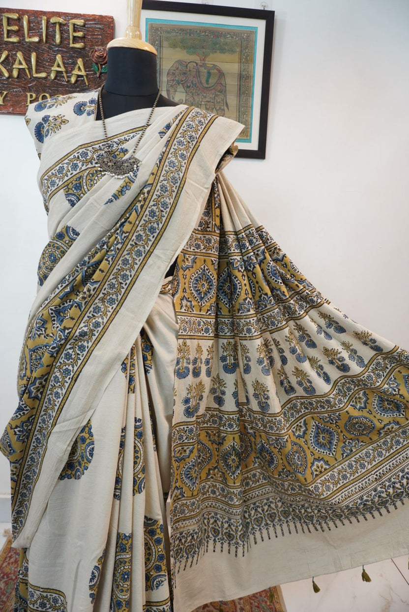 Ivory cotton Ajrakh saree with olive green, blue and yellow block print, border and tassels