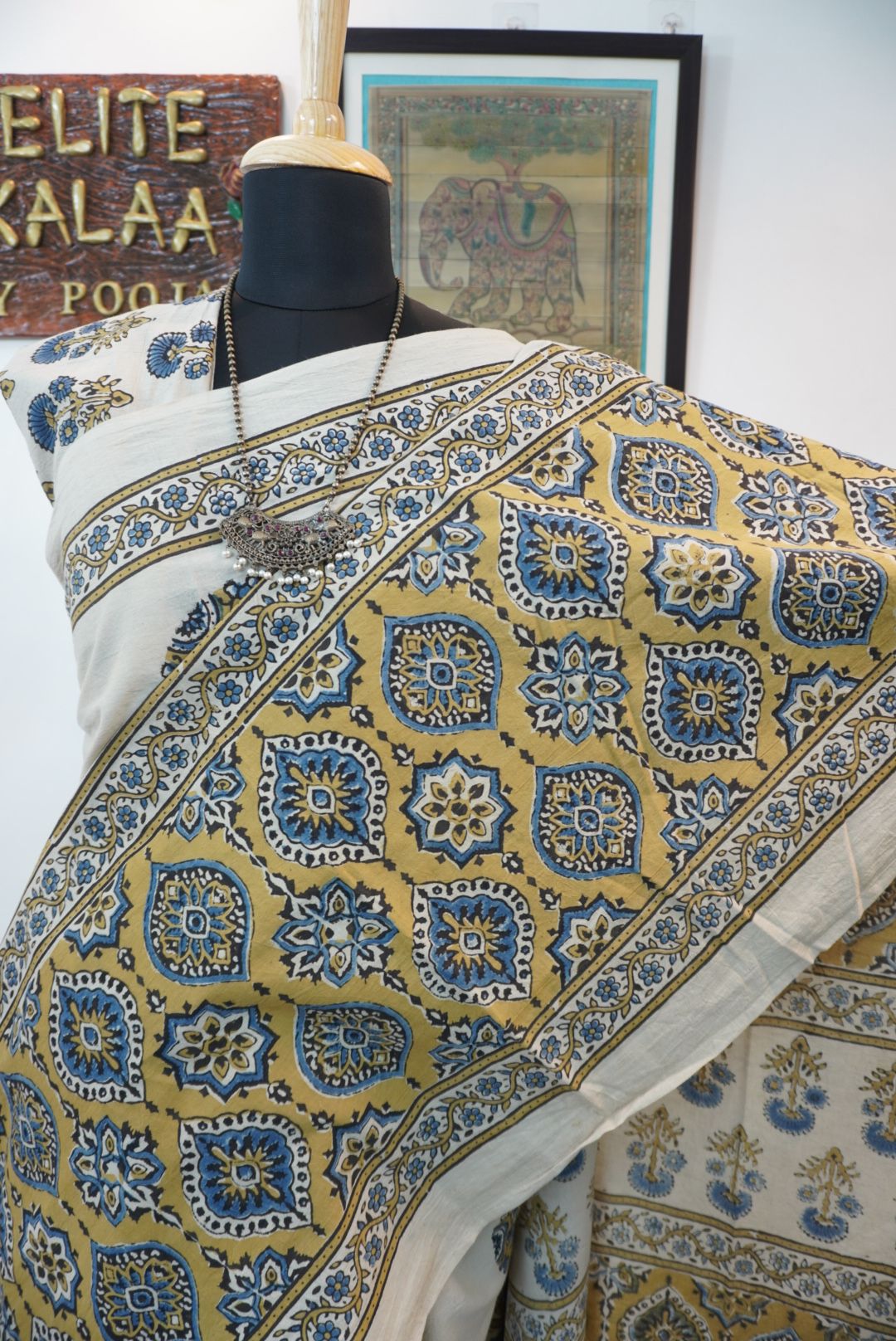 Ivory cotton Ajrakh saree with olive green, blue and yellow block print, border and tassels