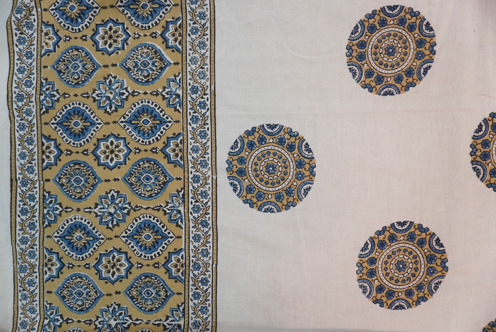 Ivory cotton Ajrakh saree with olive green, blue and yellow block print, border and tassels
