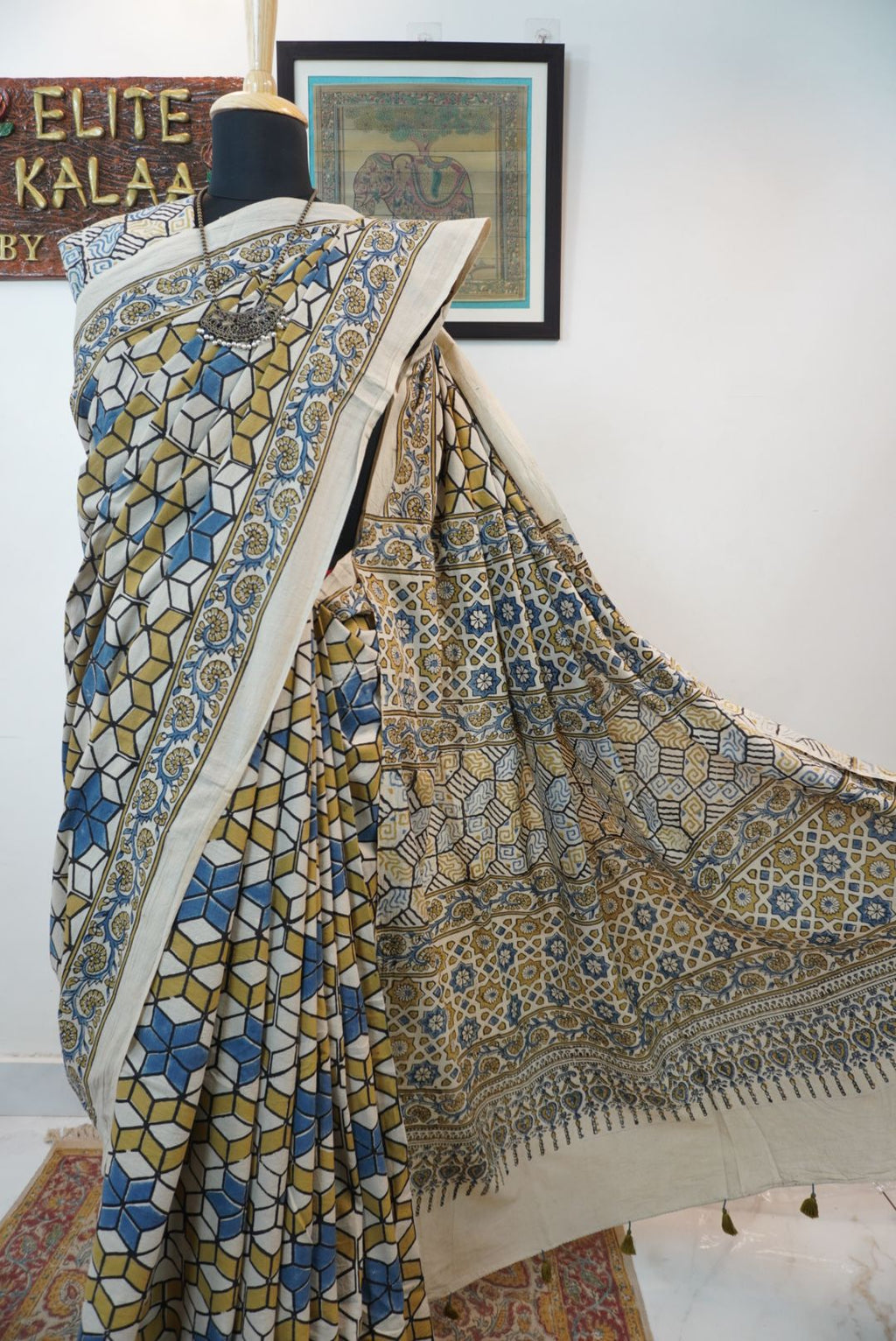 Ajrakh cotton saree in ivory with olive green, blue and yellow all-over design and border detail