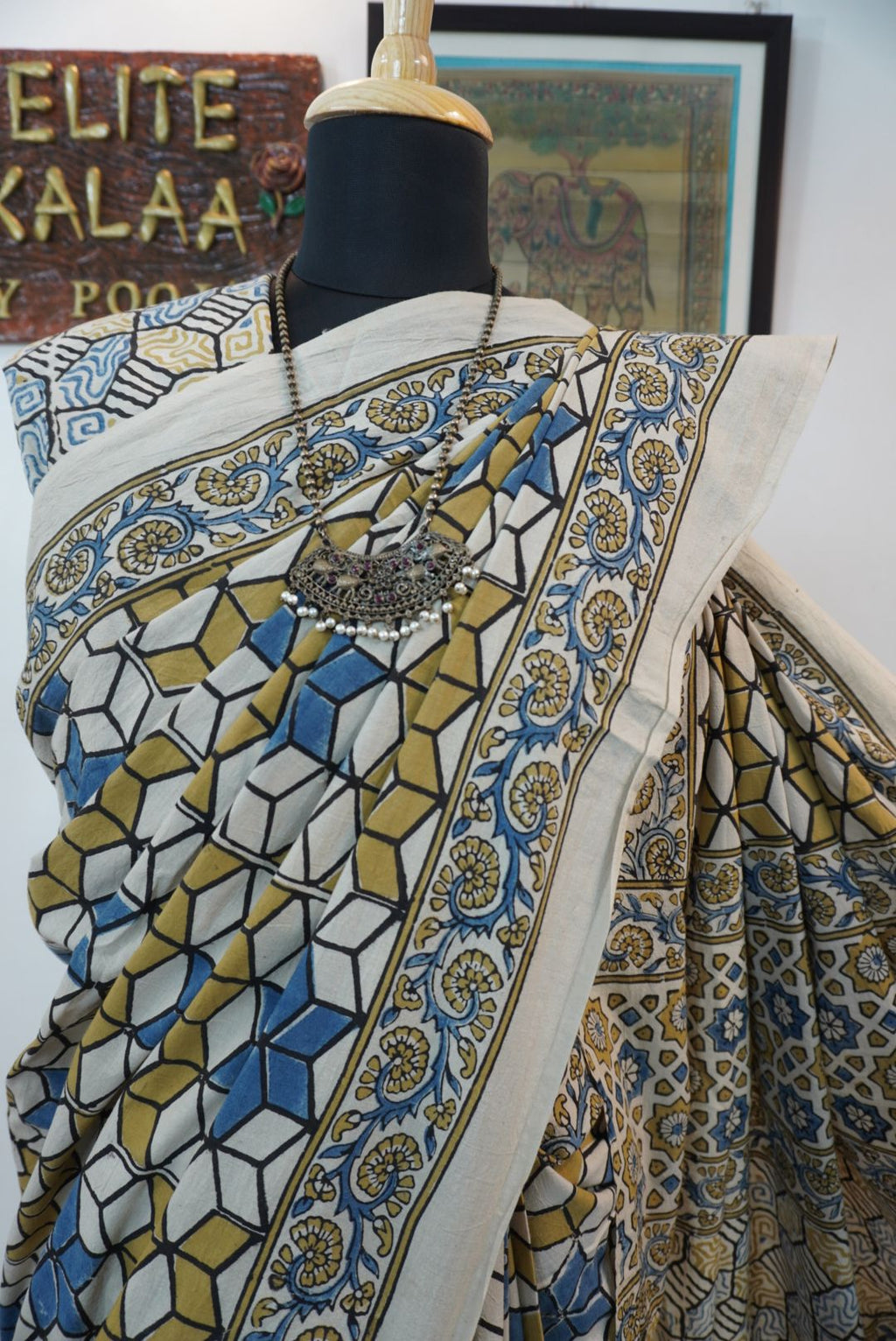 Ajrakh cotton saree in ivory with olive green, blue and yellow all-over design and border detail