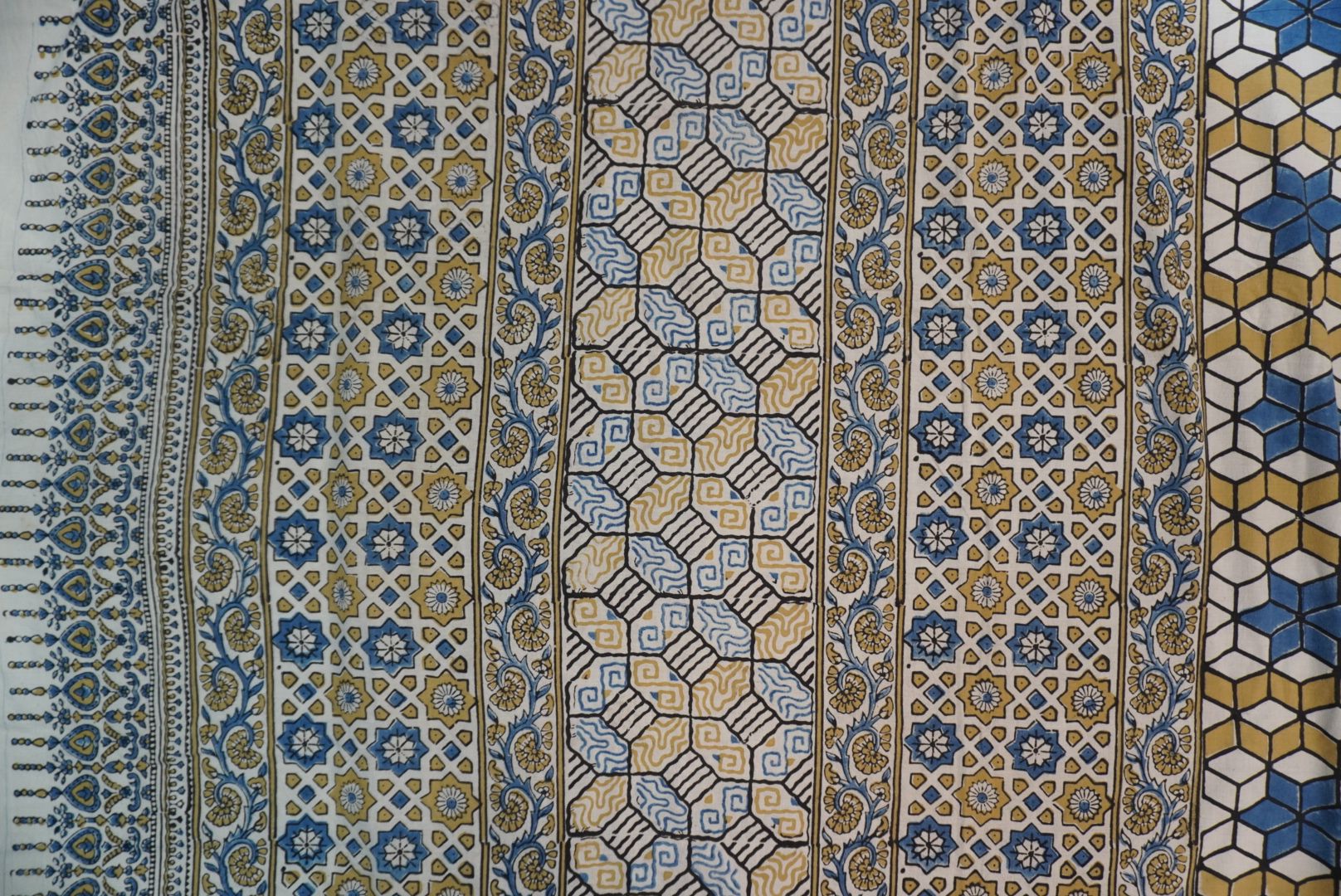 Ajrakh cotton saree in ivory with olive green, blue and yellow all-over design and border detail
