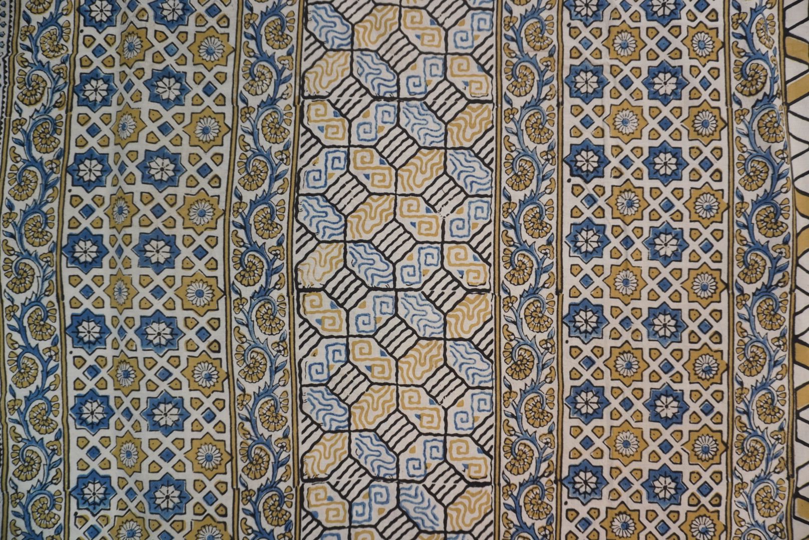 Ajrakh cotton saree in ivory with olive green, blue and yellow all-over design and border detail