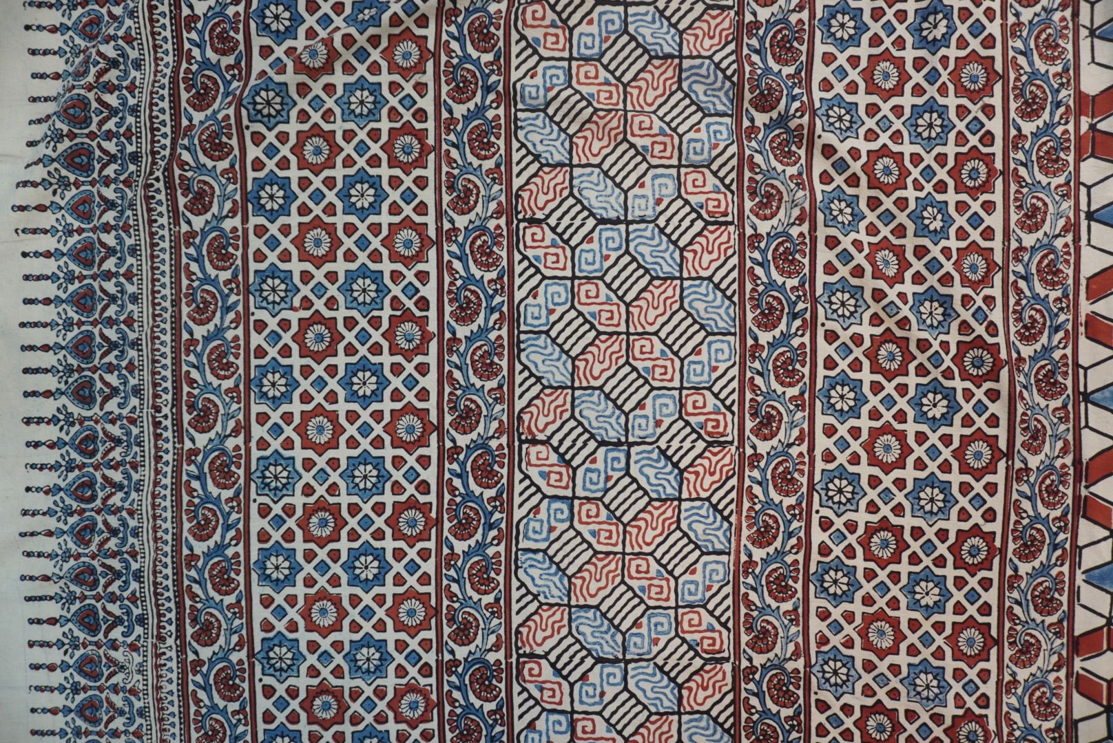 Ajrakh cotton saree in ivory with red rust and blue, all-over pattern with border and tassels
