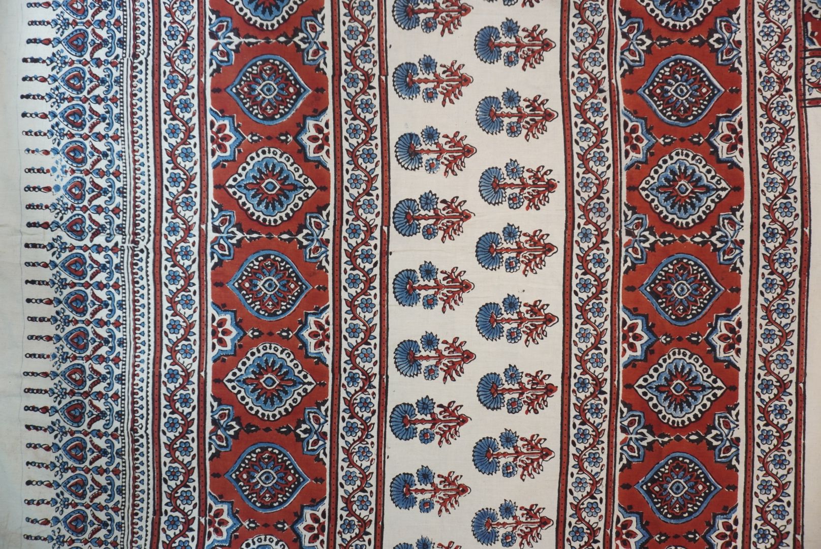Ivory Ajrakh cotton saree with red rust and blue placement pattern, border and tassels