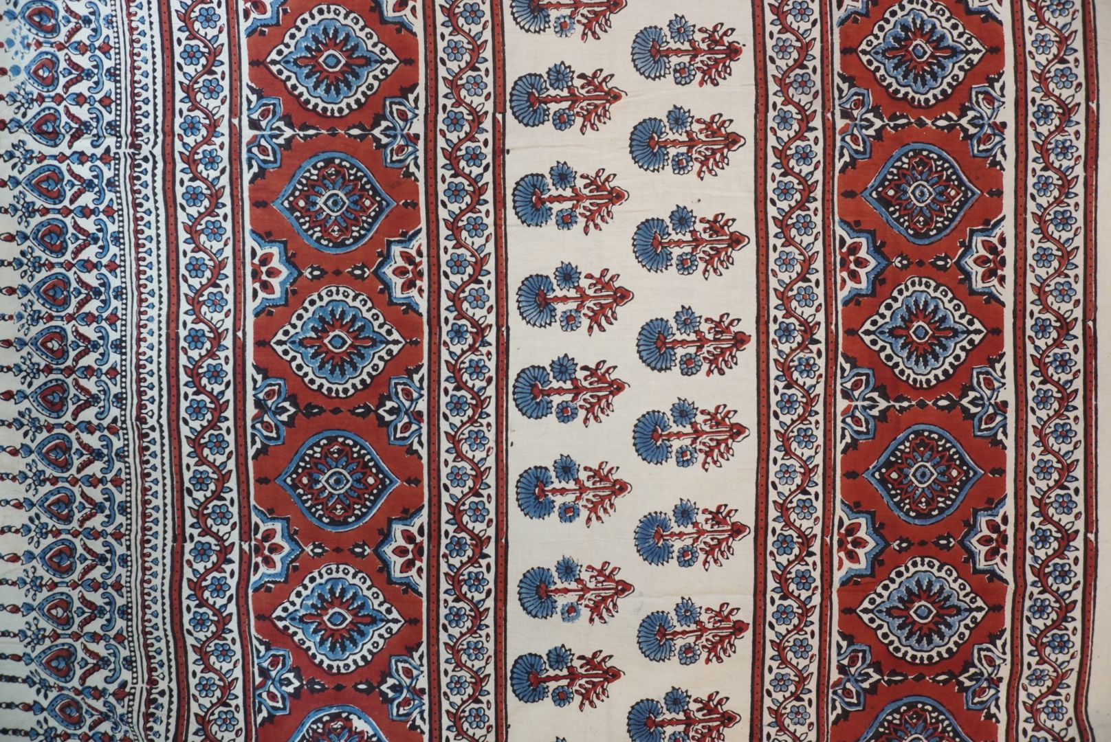 Ivory Ajrakh cotton saree with red rust and blue placement pattern, border and tassels