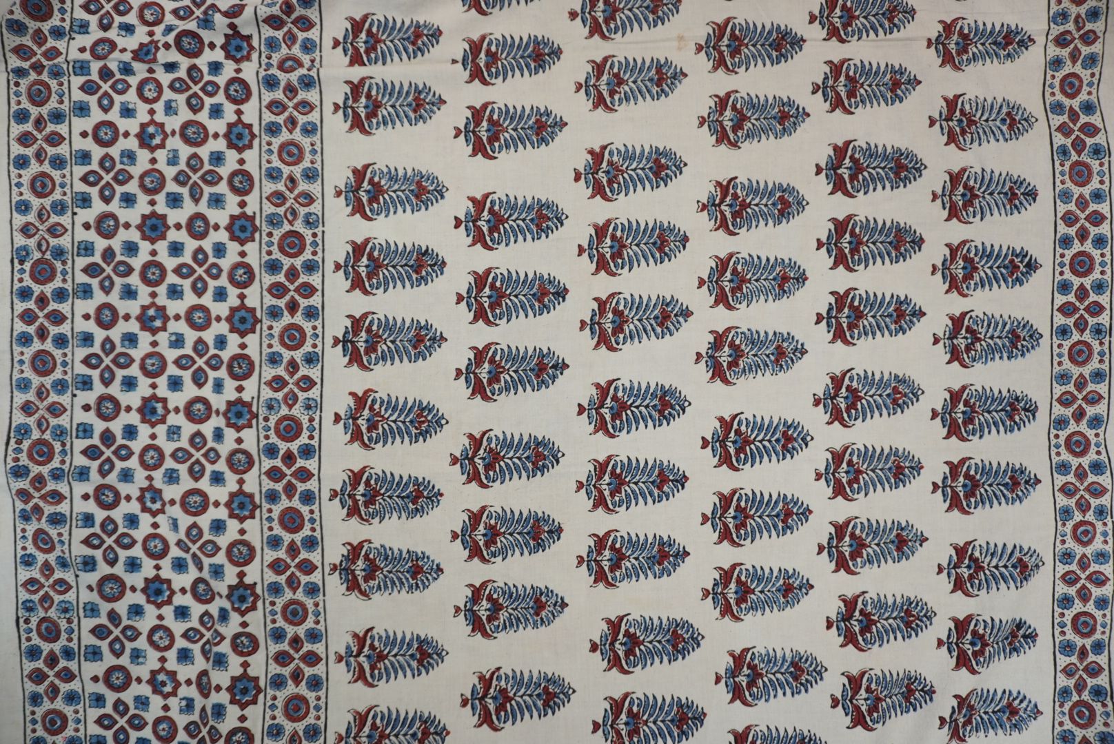 Cotton Ajrakh saree in ivory with red rust and blue, all-over pattern, border and tassels