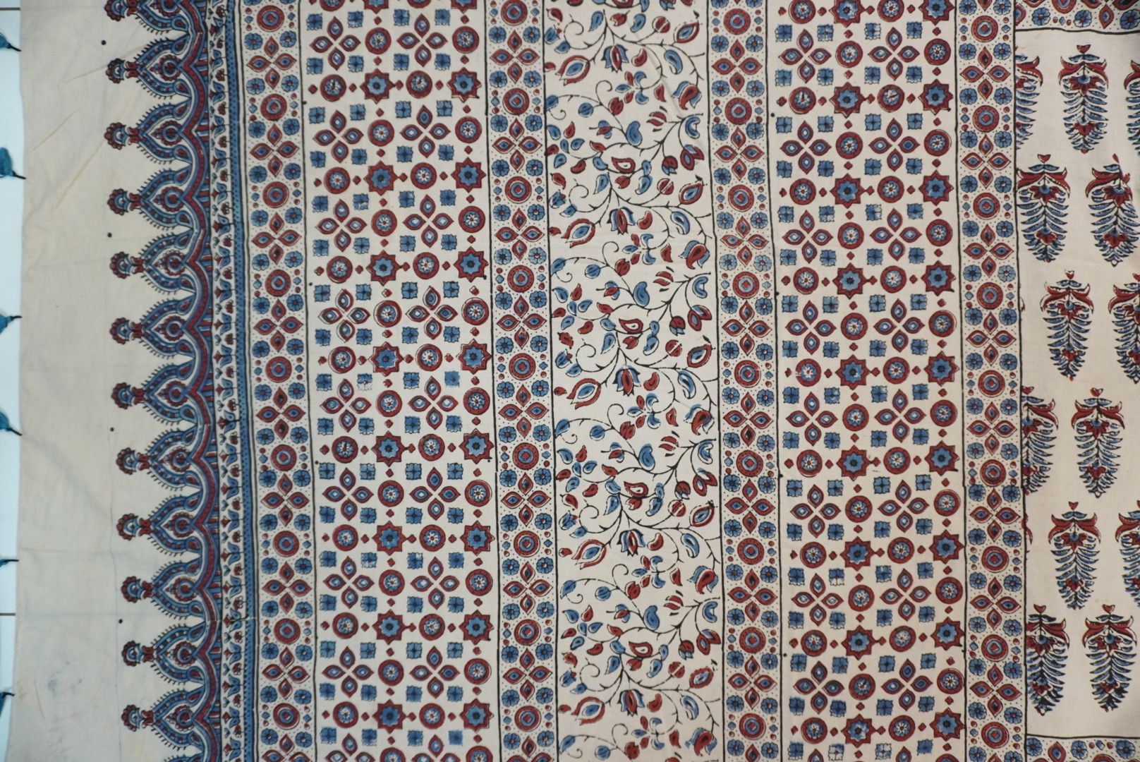 Cotton Ajrakh saree in ivory with red rust and blue, all-over pattern, border and tassels