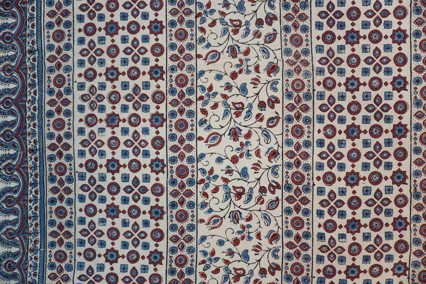 Cotton Ajrakh saree in ivory with red rust and blue, all-over pattern, border and tassels