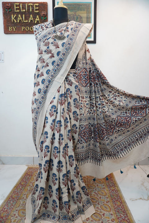 Ivory cotton Ajrakh saree with red, blue and rust placement pattern, border and tassels