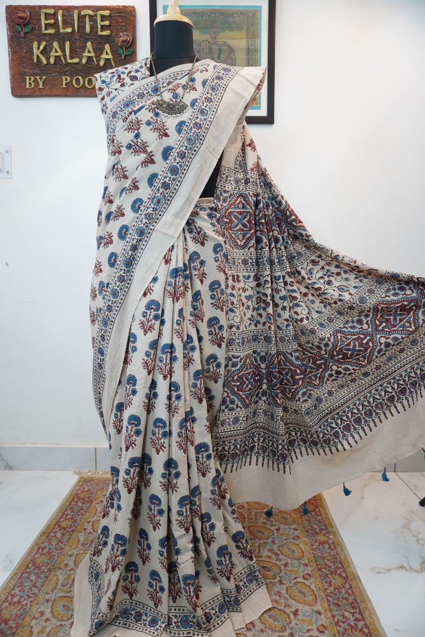 Ivory cotton Ajrakh saree with red, blue and rust placement pattern, border and tassels