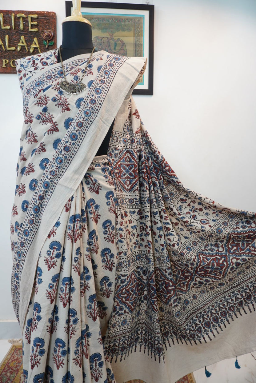 Ivory cotton Ajrakh saree with red, blue and rust placement pattern, border and tassels