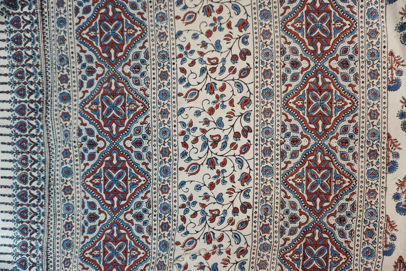 Ivory cotton Ajrakh saree with red, blue and rust placement pattern, border and tassels