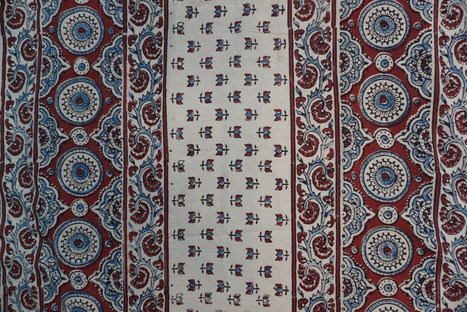 Ajrakh cotton saree in ivory with red rust and blue all-over pattern, border and tassels