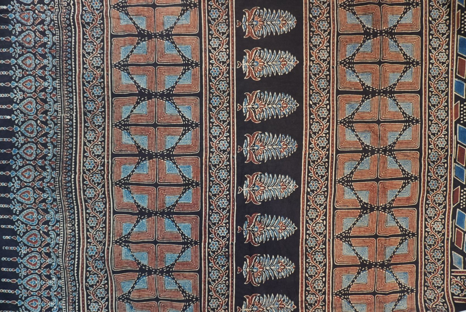Black Ajrakh cotton saree with cream, rust and blue detailing, border and tassels