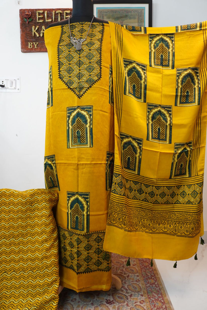 Yellow 3 piece dress material with multicolor jharokha design, border and tassels