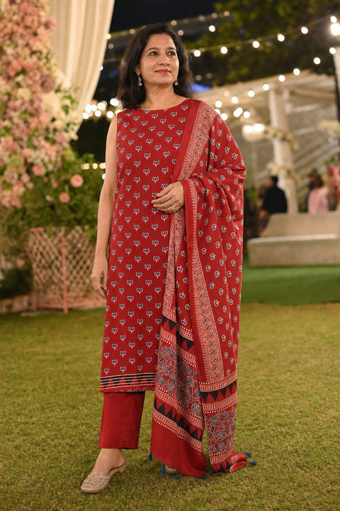 Red 3 piece suit with stole, multicolor placement pattern and small lotus design with border and tassels