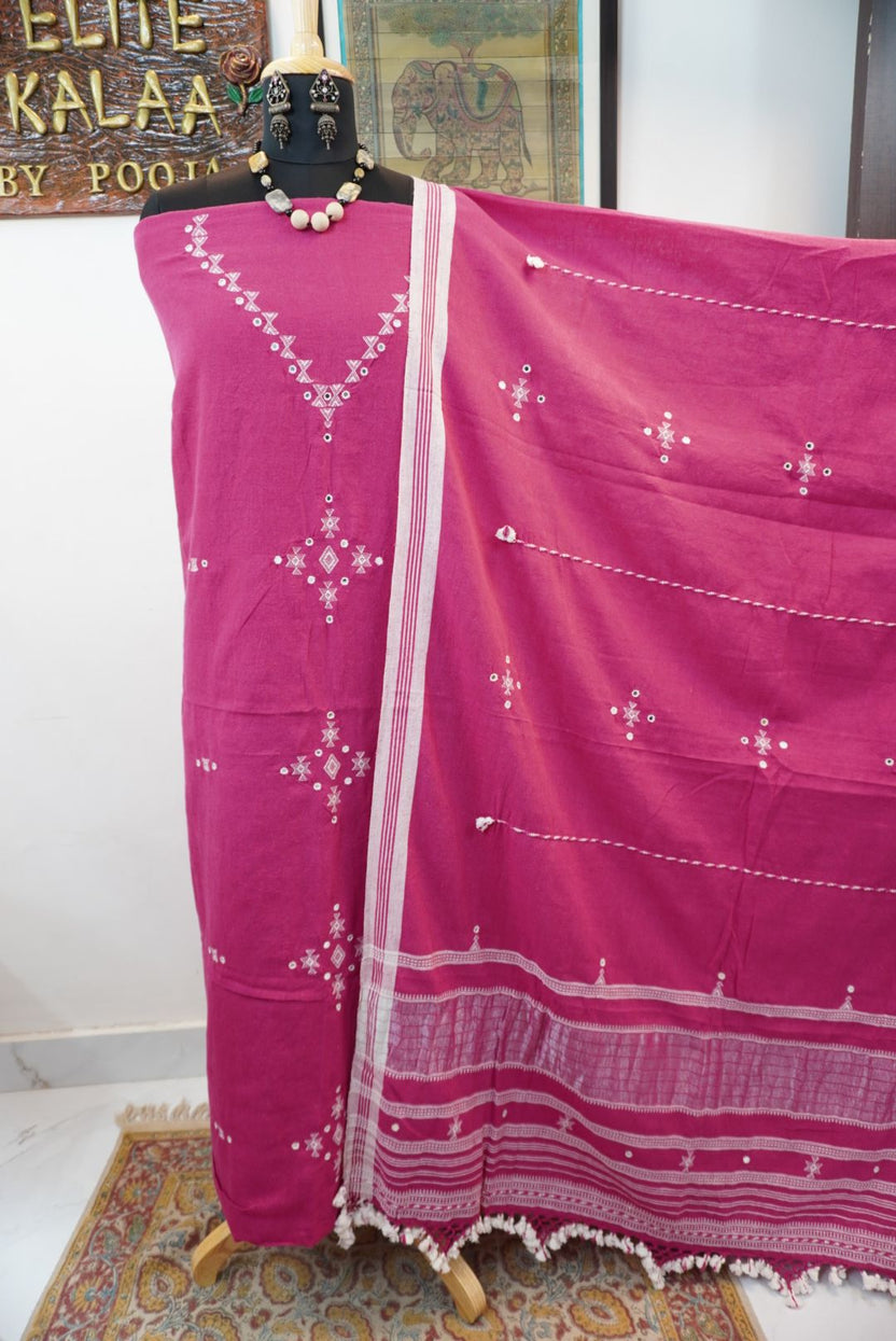 Magenta pink suit fabric with white geometric pattern, border, tassels and fringe