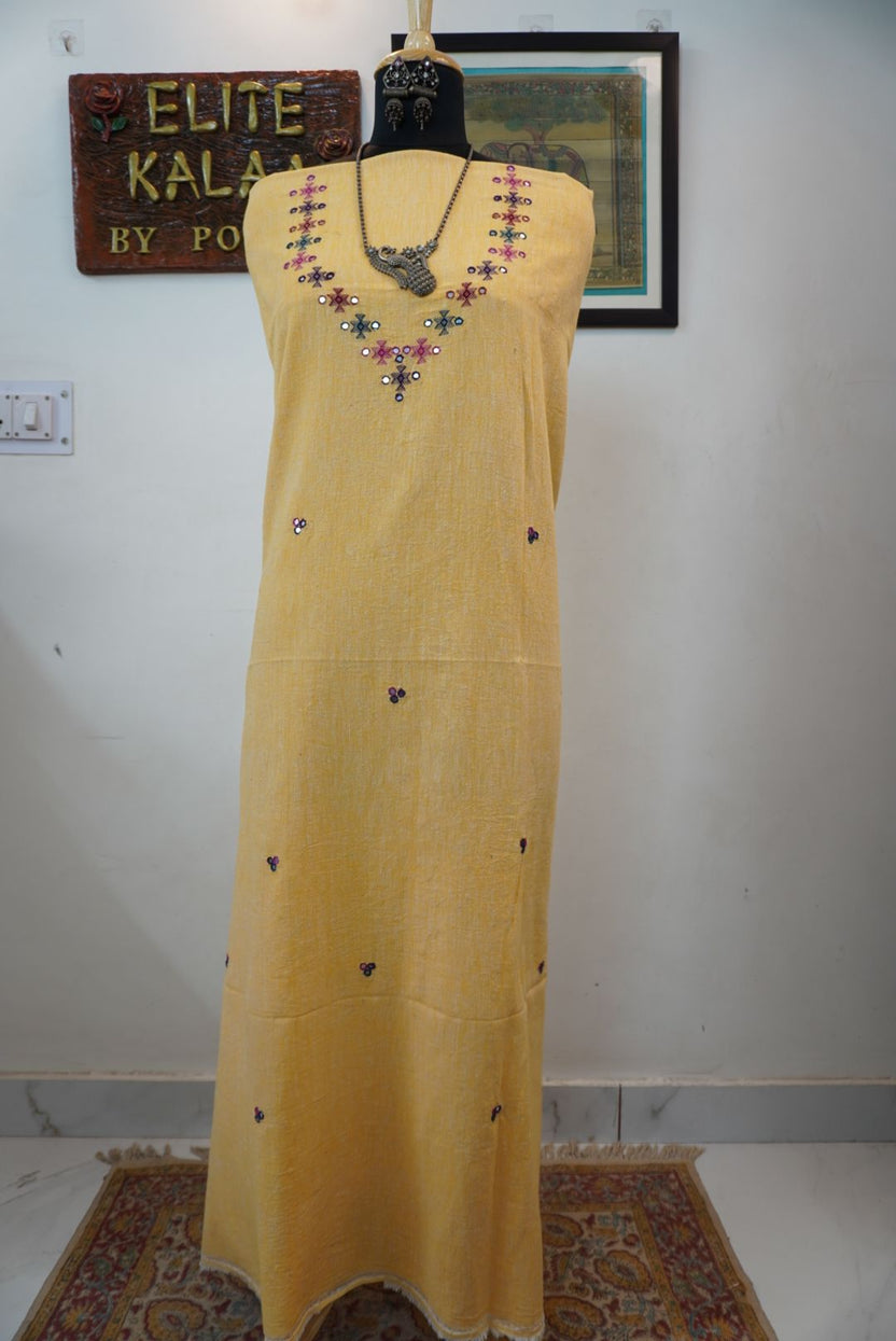 Yellow kurti with neck chomuk design, placement pattern and visible mirror work