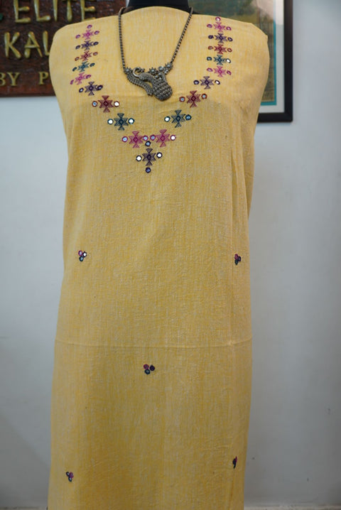 Yellow kurti with neck chomuk design, placement pattern and visible mirror work