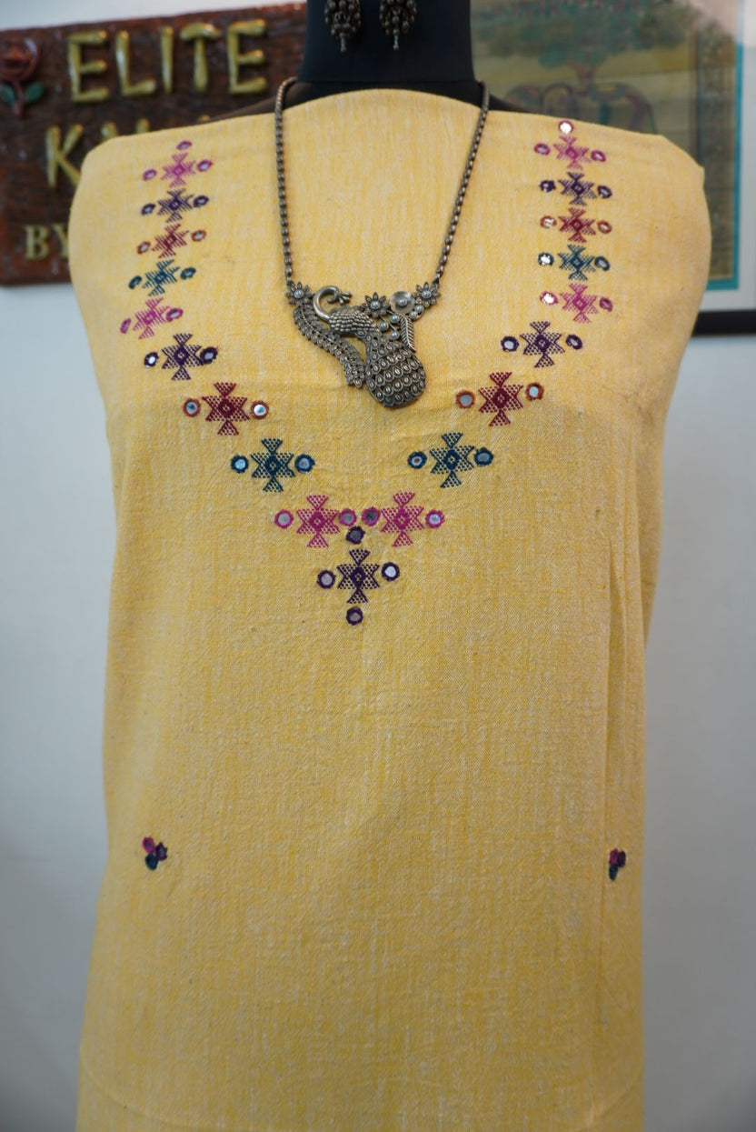 Yellow kurti with neck chomuk design, placement pattern and visible mirror work