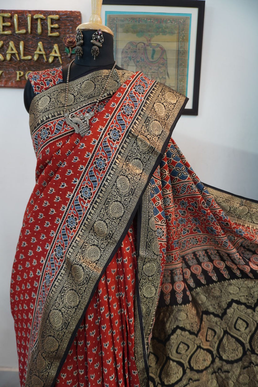 Red block print saree with black, beige and blue floral nakshi palla, small lotus boota and border