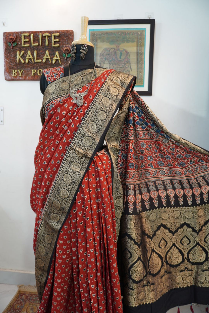 Red block print saree with black, beige and blue floral nakshi palla, small lotus boota and border