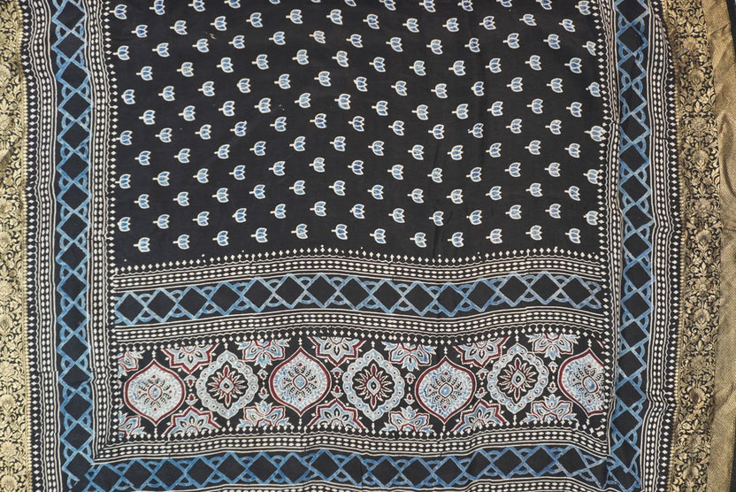 Black Dola silk Ajrakh handblock saree with all-over multicolor design, border and tassels