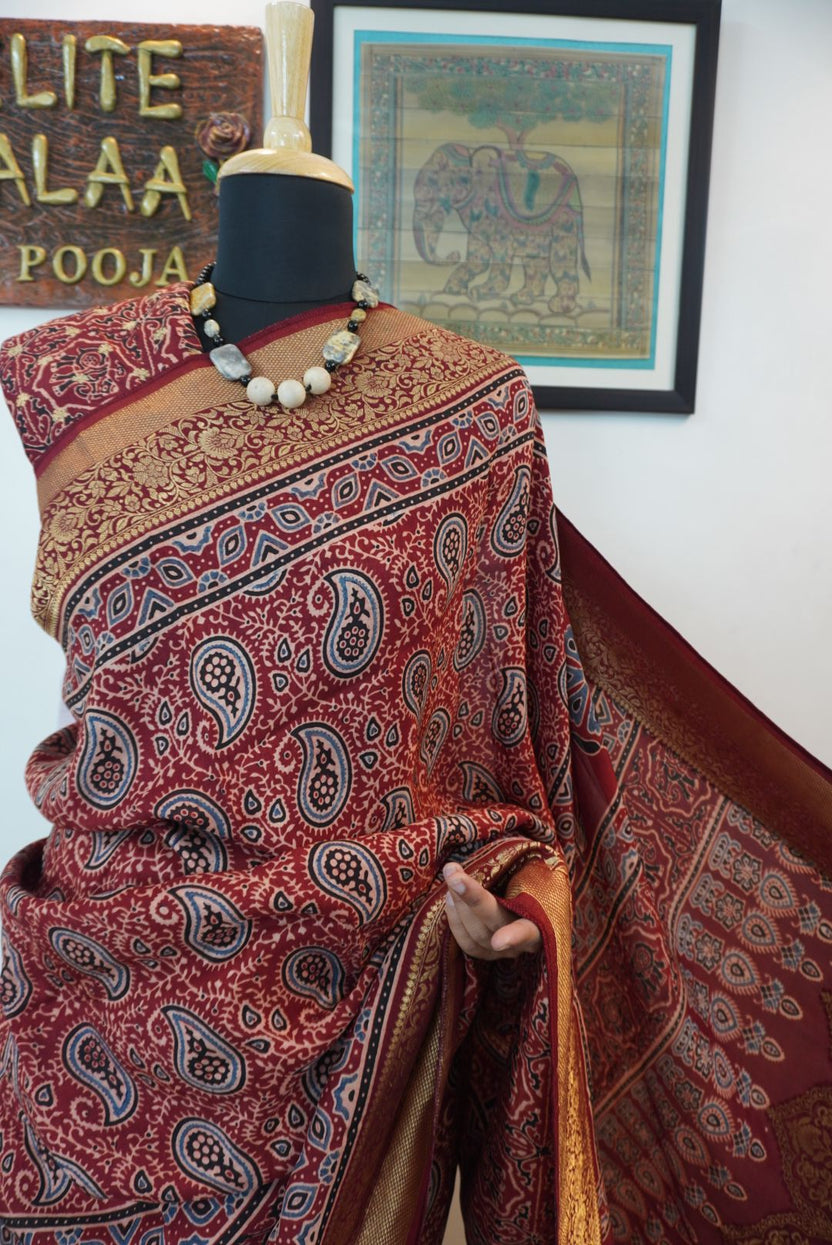 Red Dola silk saree with floral ajrakh pattern, multicolor detailing, border, zari accents and tassels
