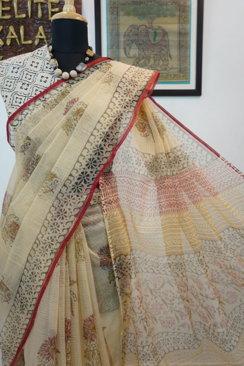 Cream saree with all-over multicolor design in red, black, yellow and brown and a border