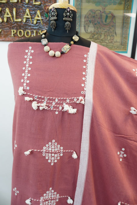 Pink dress material with geometric design, border detail and tassels